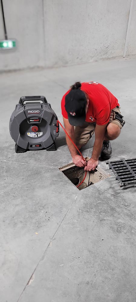 Photo du petit déboucheur savoyard réalisant le débouchage manuel d'une canalisation